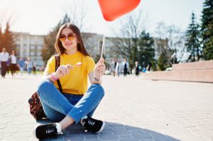 Healthy Young Adult Happy Eating a Lollipop